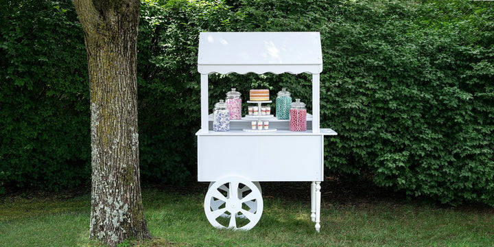ZETY white candy cart styled with candy jars and a cake, set up outdoors