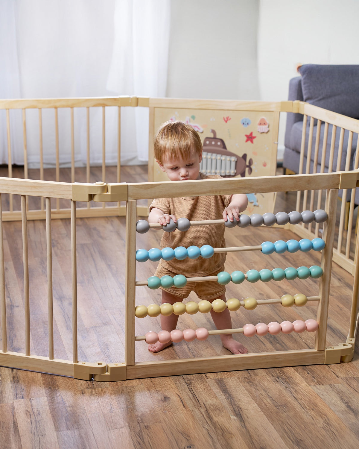 Toddler playing inside a ZETY wooden playpen