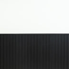 Black wainscot slat panels finished with top molding against a white upper wall