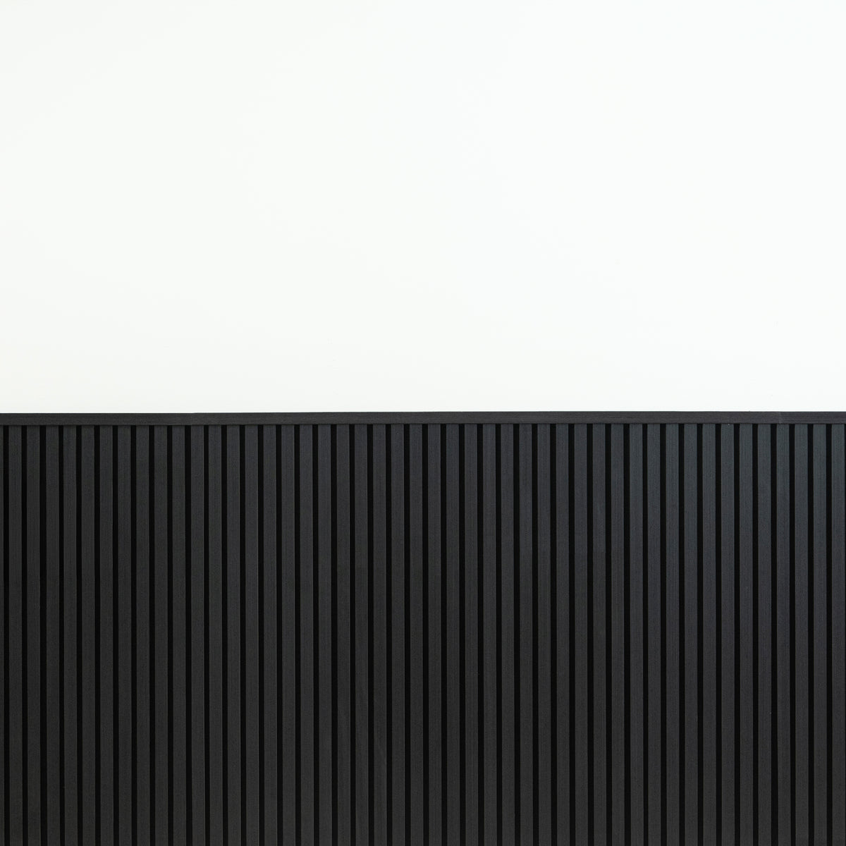 Black wainscot slat panels finished with top molding against a white upper wall