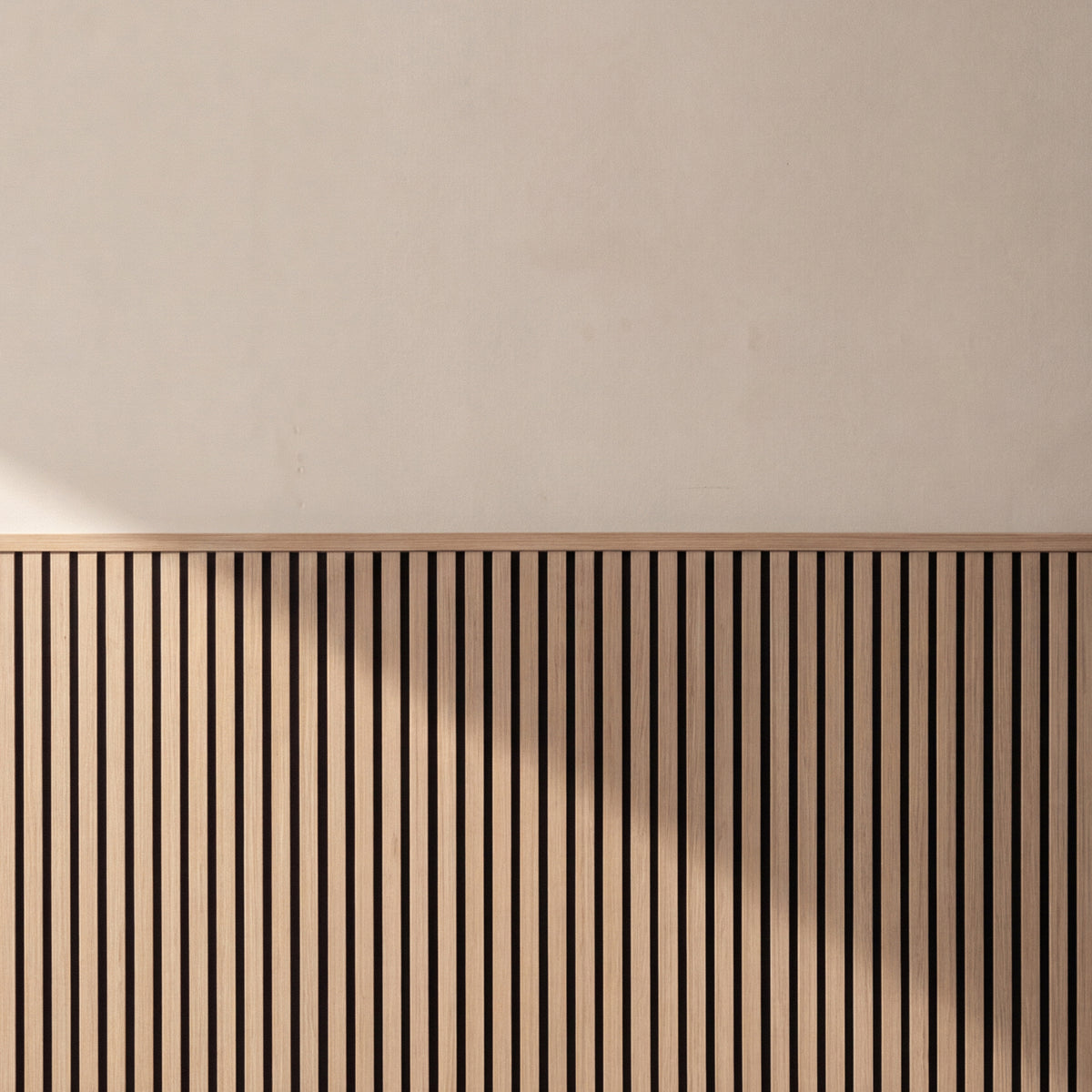 Oak acoustic wainscot panels as a half-wall accent behind furniture in a living space