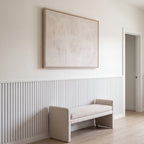 White acoustic wainscot panels as a half-wall accent behind furniture in a living space