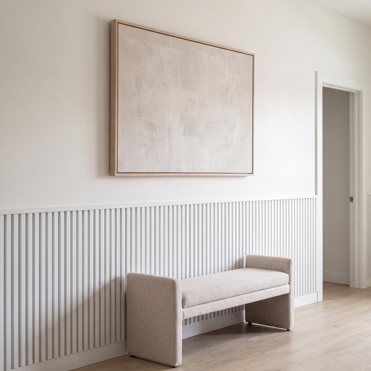 White acoustic wainscot panels as a half-wall accent behind furniture in a living space