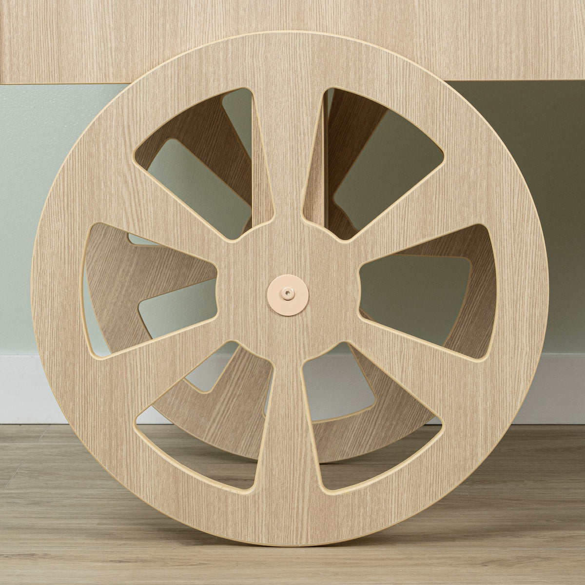 Detail of the large spoked front wheel on the wood-look candy cart
