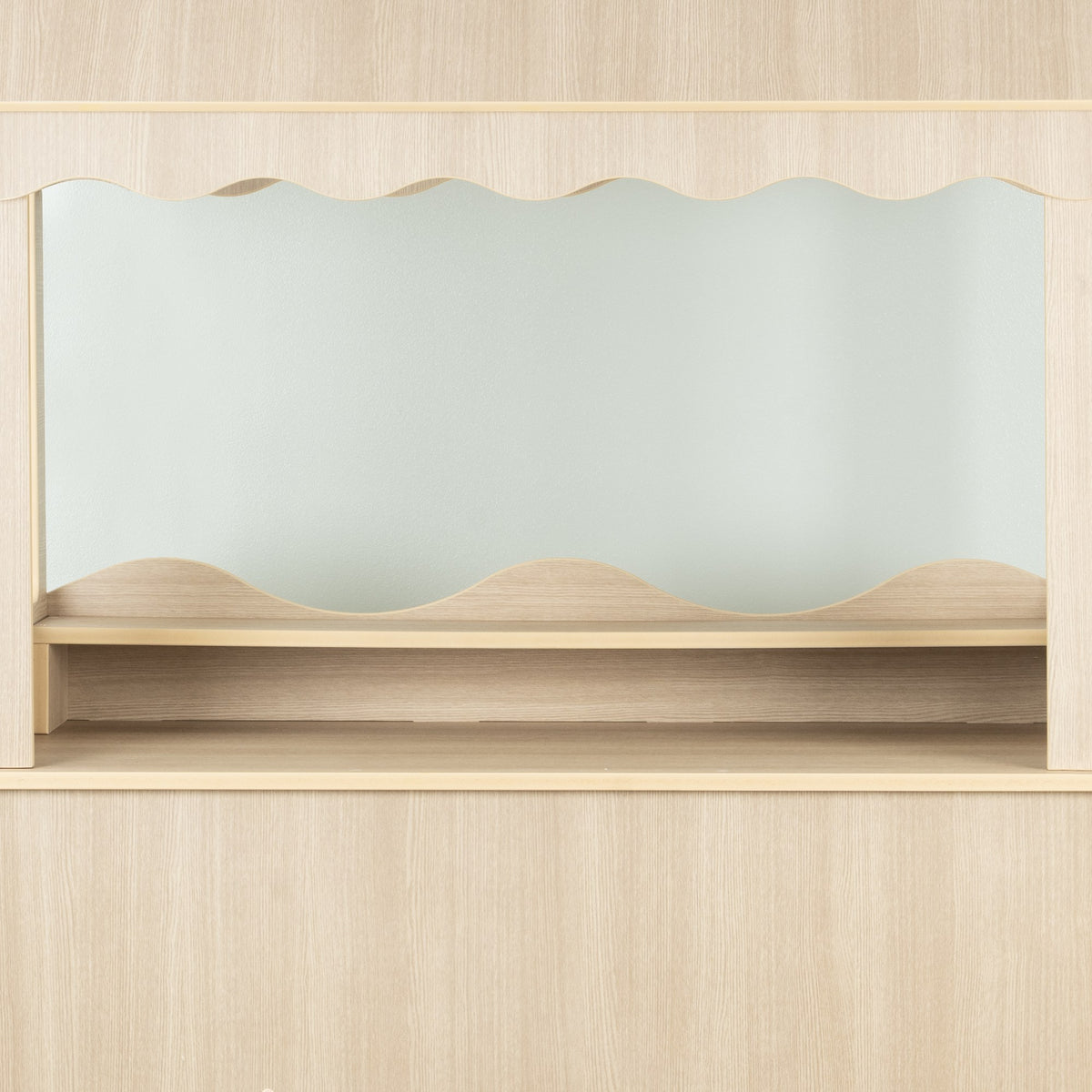 Empty wood-look candy cart counter and lower shelf against a pale wall